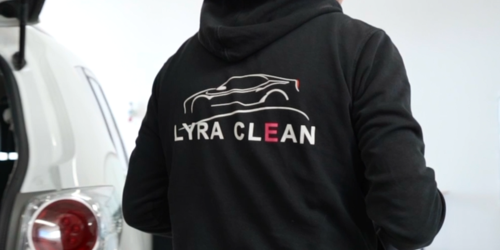 LyraClean vises på sort trøje med bil i baggrund